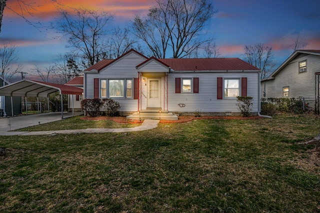 bungalow featuring a lawn, fence, concrete driveway, and a detached carport