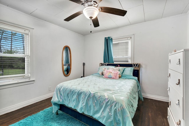 bedroom featuring wood finished floors, a ceiling fan, baseboards, and ornamental molding