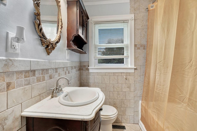 full bathroom with tile patterned floors, toilet, ornamental molding, a shower with curtain, and tile walls