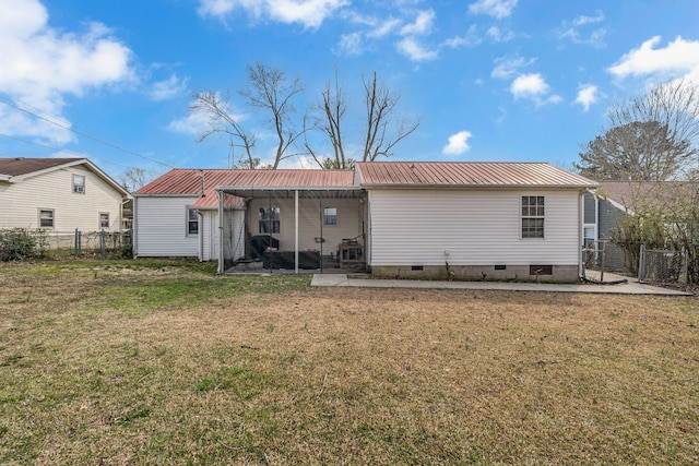 back of property with a lawn, crawl space, fence, and metal roof