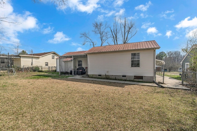 back of property with fence, crawl space, a yard, and metal roof