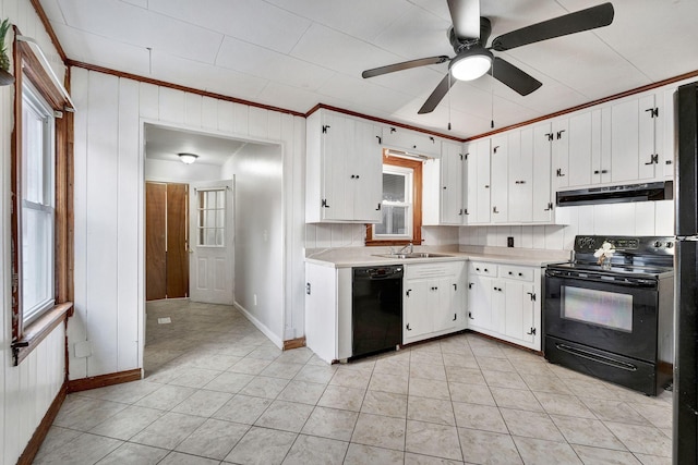 kitchen featuring a sink, black appliances, light countertops, baseboards, and under cabinet range hood