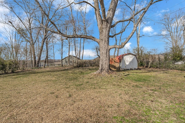 view of yard featuring fence, an outdoor structure, and a shed