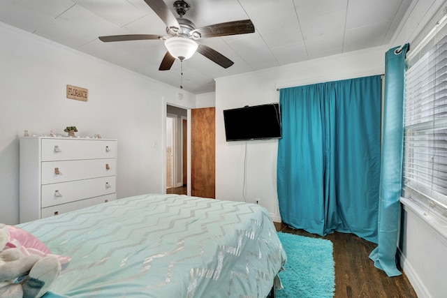 bedroom featuring ceiling fan, crown molding, and wood finished floors