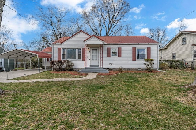 view of front of home featuring concrete driveway, a front lawn, a carport, fence, and metal roof