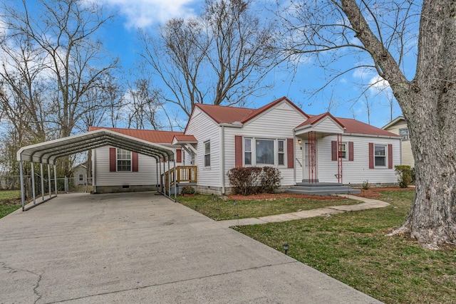 view of front of property with metal roof, a detached carport, a front yard, and concrete driveway