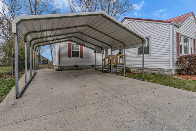 view of vehicle parking featuring driveway, a carport, and fence
