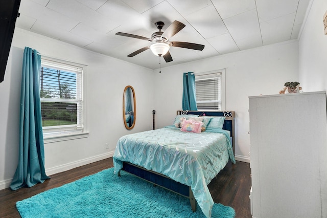 bedroom featuring baseboards, a ceiling fan, wood finished floors, and ornamental molding