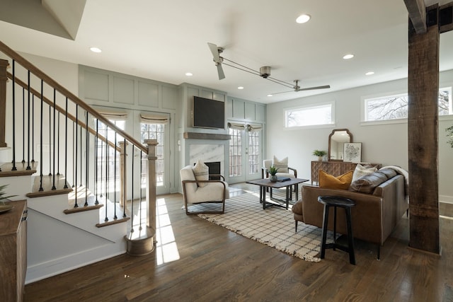 living area with recessed lighting, a fireplace, stairs, and dark wood-type flooring