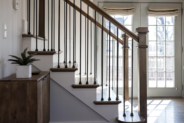 stairway featuring a healthy amount of sunlight and wood finished floors