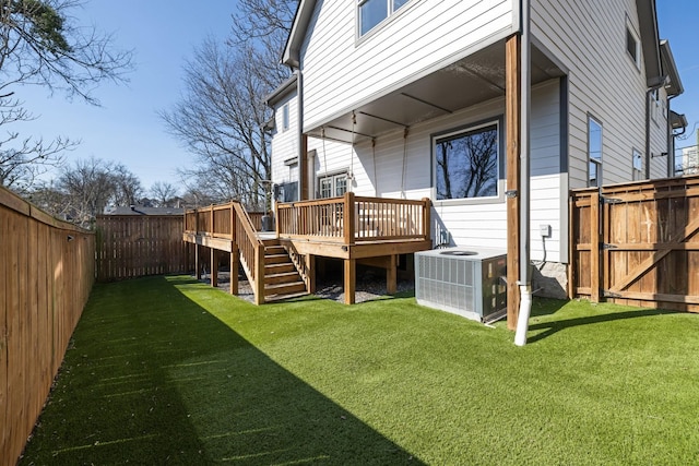 view of yard featuring a deck, central AC unit, a fenced backyard, and stairs