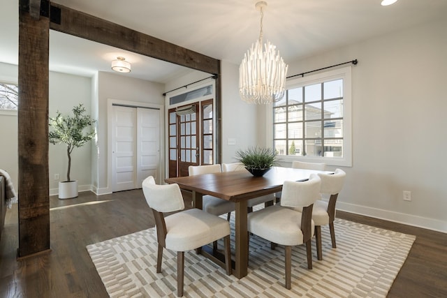 dining area with plenty of natural light, an inviting chandelier, baseboards, and wood finished floors