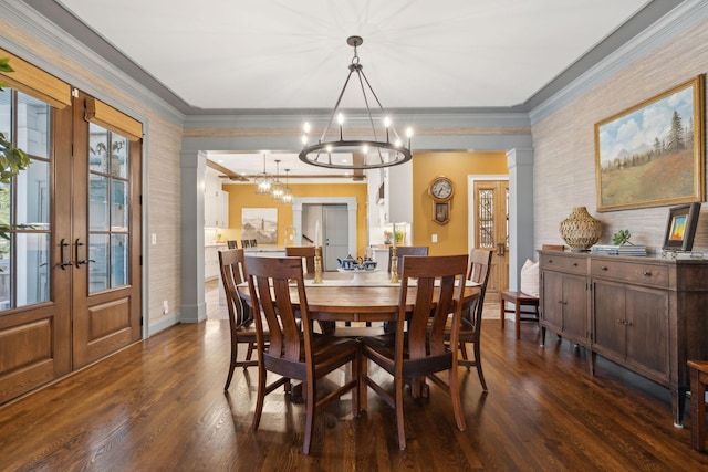 dining room featuring french doors, dark wood-type flooring, an inviting chandelier, and ornamental molding