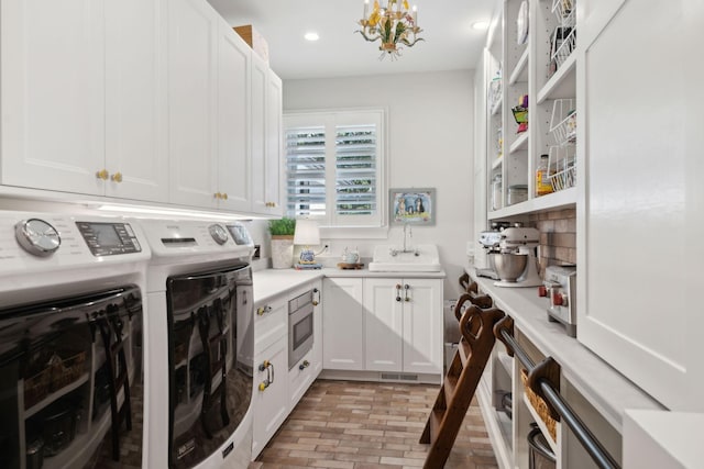 washroom featuring visible vents, a notable chandelier, recessed lighting, separate washer and dryer, and brick floor