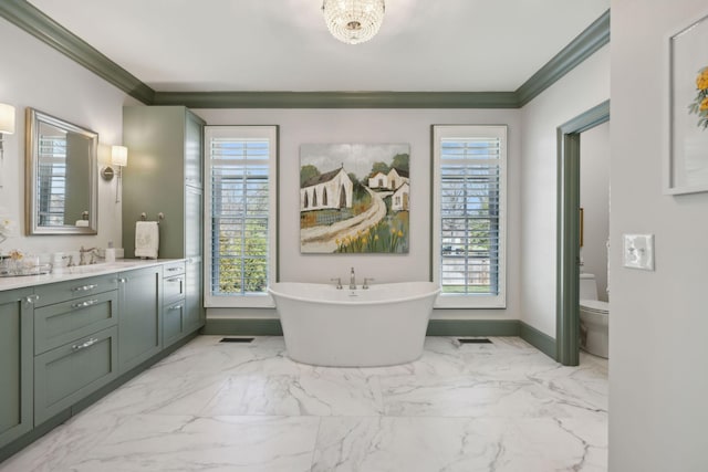 full bathroom with crown molding, a freestanding bath, toilet, marble finish floor, and vanity