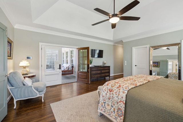 bedroom featuring a tray ceiling, wood finished floors, and ornamental molding