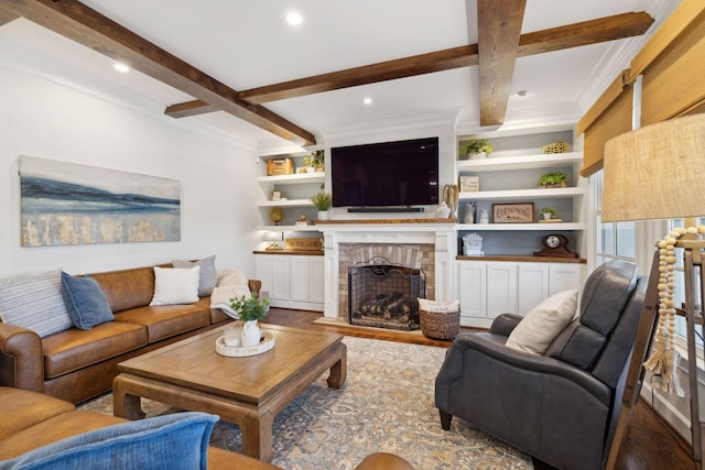 living area with built in features, beam ceiling, a fireplace, recessed lighting, and crown molding