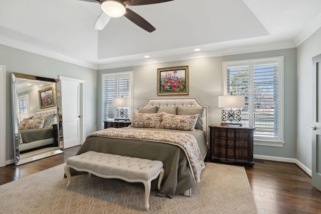 bedroom featuring crown molding, a raised ceiling, baseboards, and wood finished floors