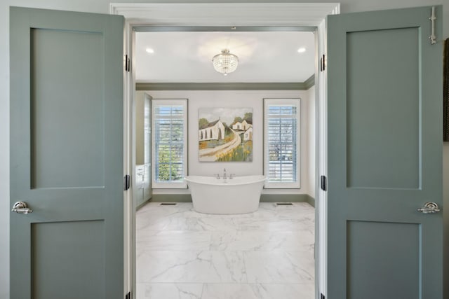 full bath featuring crown molding, baseboards, recessed lighting, a freestanding tub, and marble finish floor