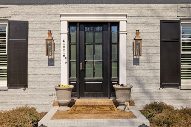 view of exterior entry with brick siding