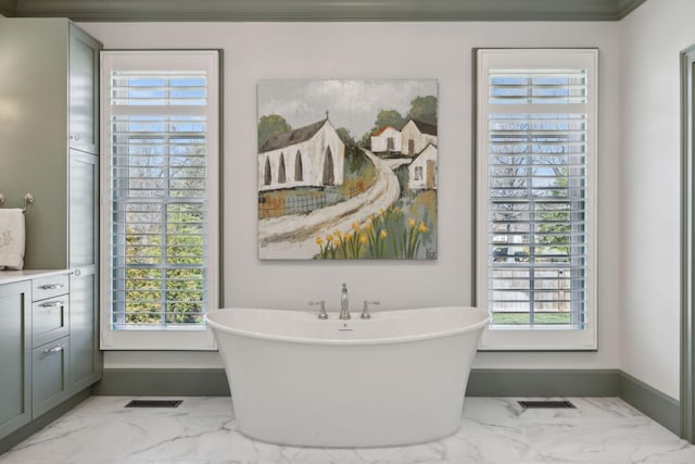 full bath with a soaking tub, plenty of natural light, and marble finish floor