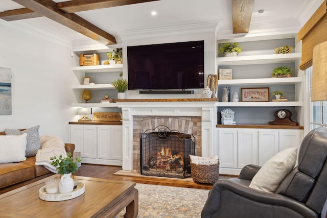 living area with built in features, beamed ceiling, wood finished floors, and ornamental molding