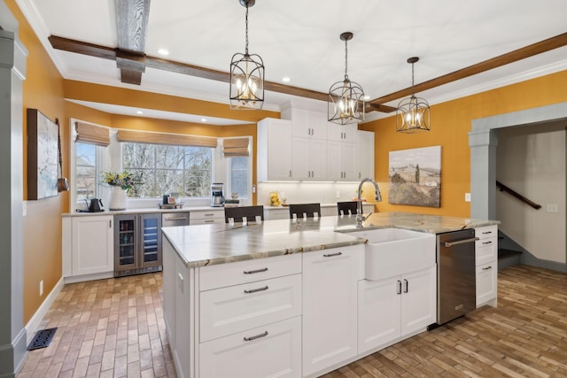 kitchen featuring beverage cooler, white cabinets, crown molding, and a sink