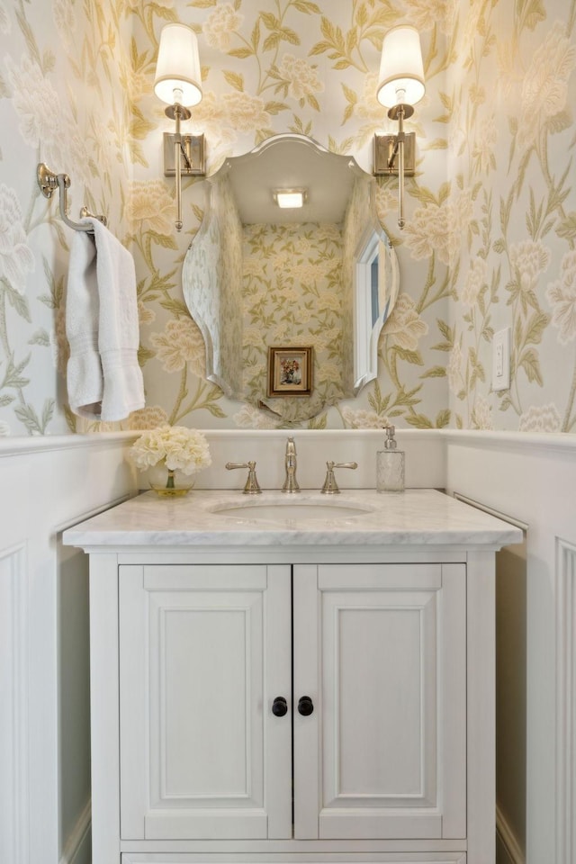 bathroom featuring vanity and wallpapered walls