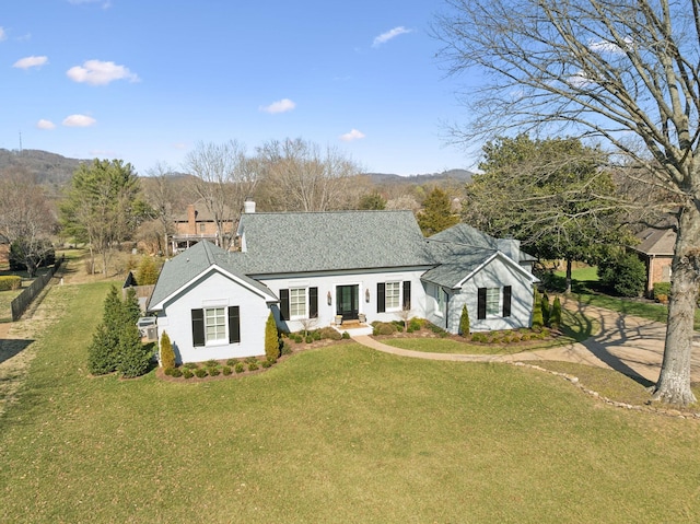 view of front facade with a chimney and a front lawn