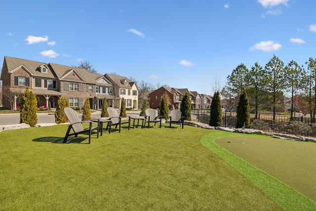 view of home's community featuring a yard, a residential view, and fence