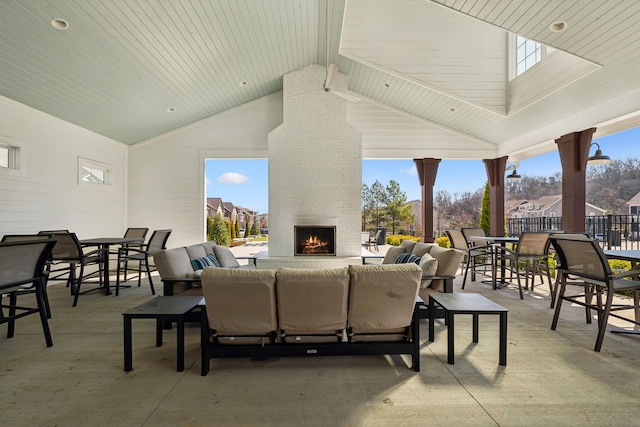 view of patio / terrace featuring outdoor dining area, fence, and an outdoor living space with a fireplace