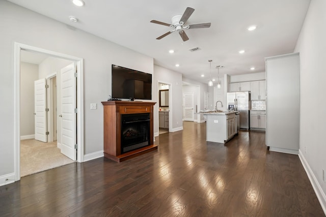 living room with dark wood-style floors, visible vents, recessed lighting, and ceiling fan