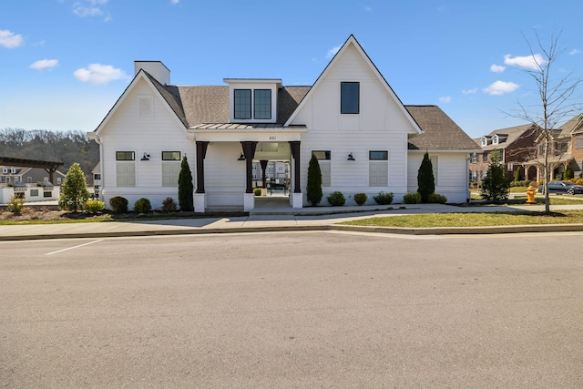 modern farmhouse style home featuring metal roof, a shingled roof, and a standing seam roof