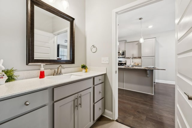 bathroom featuring baseboards, wood finished floors, and vanity