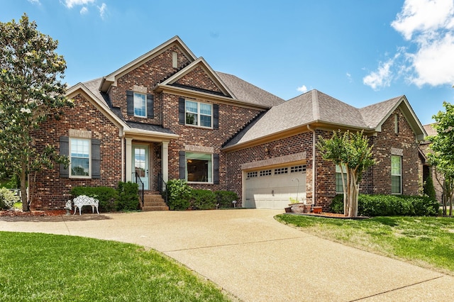 view of front of property with brick siding, an attached garage, driveway, and a front yard