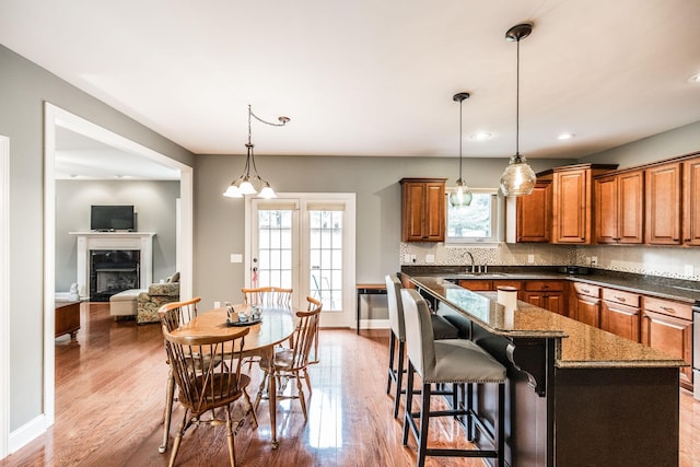 1013 Five Coves Trce, Gallatin, TN 37066 - kitchen with a sink, decorative backsplash, brown cabinetry, and light wood finished floors