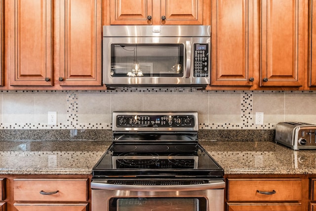 1013 Five Coves Trce, Gallatin, TN 37066 - kitchen with tasteful backsplash, a toaster, brown cabinets, and appliances with stainless steel finishes