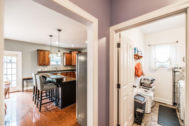 1013 Five Coves Trce, Gallatin, TN 37066 - kitchen with a wealth of natural light, dark countertops, a breakfast bar area, and brown cabinetry