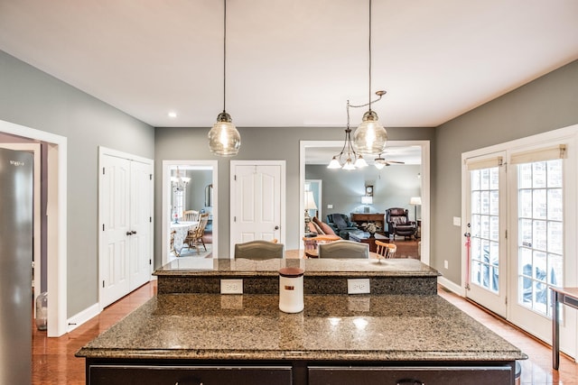 1013 Five Coves Trce, Gallatin, TN 37066 - kitchen with a kitchen island, baseboards, dark stone countertops, wood finished floors, and hanging light fixtures