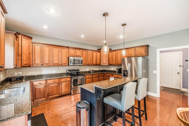 1013 Five Coves Trce, Gallatin, TN 37066 - kitchen featuring a kitchen bar, brown cabinetry, and stainless steel appliances