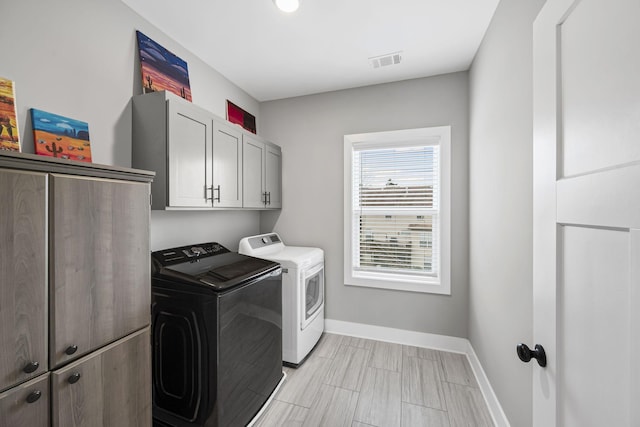 laundry room featuring visible vents, cabinet space, baseboards, and washer and clothes dryer