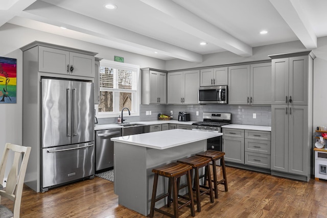 kitchen with a sink, dark wood-type flooring, appliances with stainless steel finishes, and gray cabinets