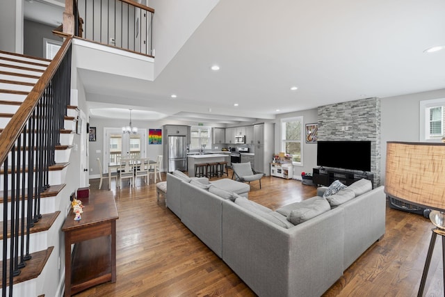 living area featuring dark wood-type flooring, stairway, and plenty of natural light