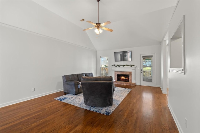 living area featuring visible vents, a brick fireplace, baseboards, ceiling fan, and wood finished floors