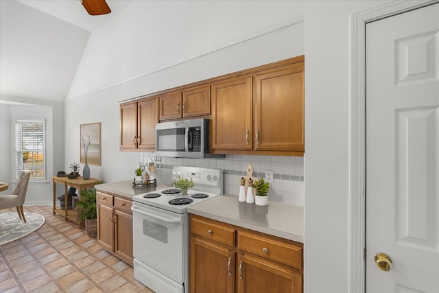 kitchen with stainless steel microwave, backsplash, light countertops, lofted ceiling, and white electric range