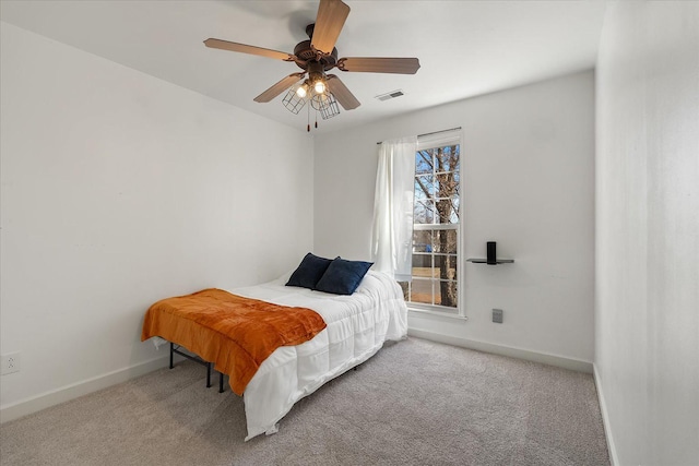 carpeted bedroom with visible vents, baseboards, and a ceiling fan