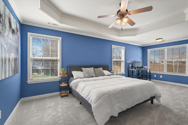 bedroom with visible vents, crown molding, baseboards, a tray ceiling, and carpet flooring