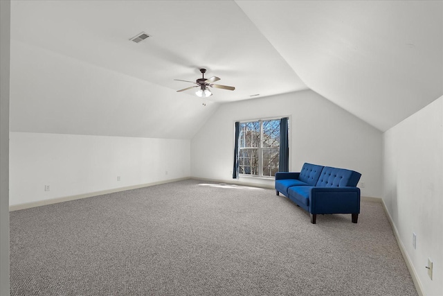 living area featuring baseboards, ceiling fan, carpet flooring, and vaulted ceiling