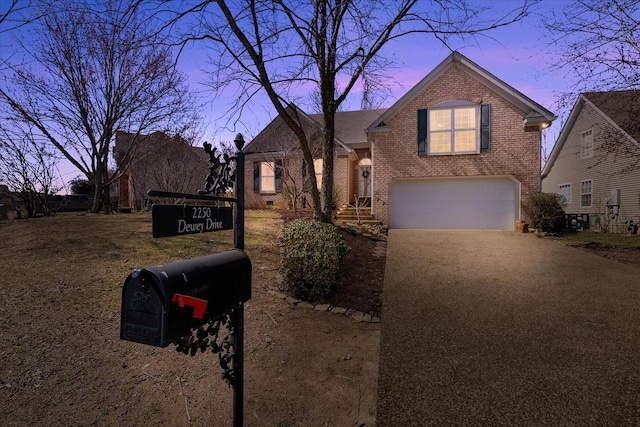 view of front facade with brick siding, driveway, and a garage