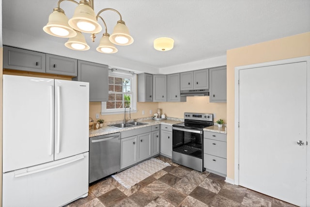 kitchen with a sink, gray cabinetry, light countertops, under cabinet range hood, and appliances with stainless steel finishes